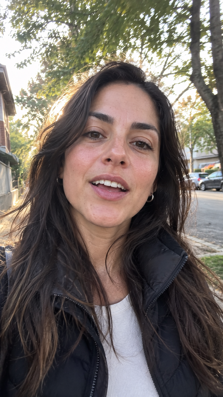 Mujer con campera negra hablando a cámara en la calle con luz de atardecer